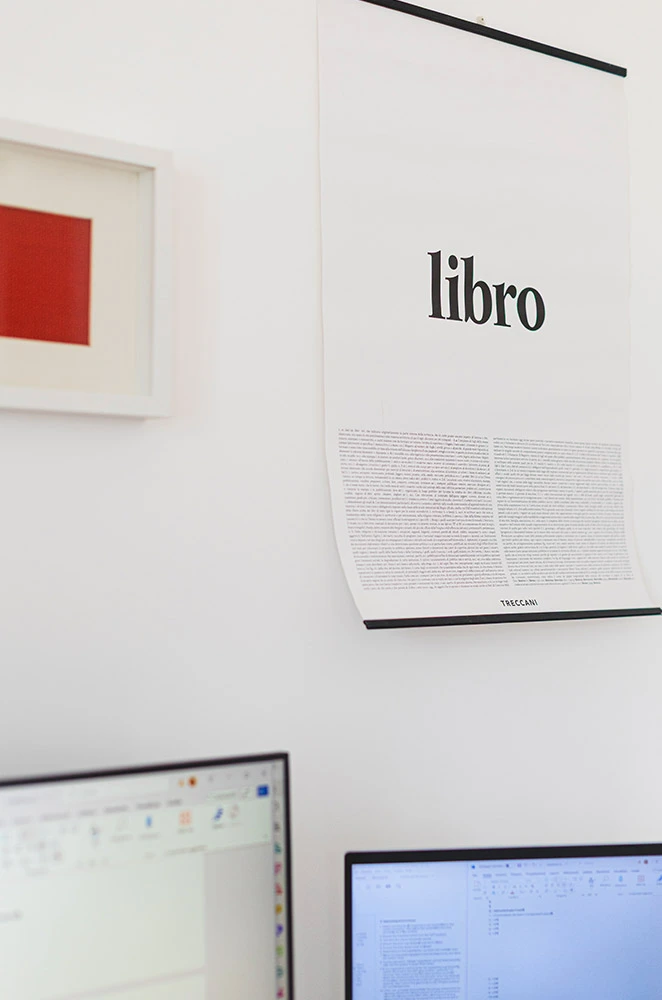 Poster con la definizione di "libro" della Treccani, appeso sopra la scrivania di Silvia